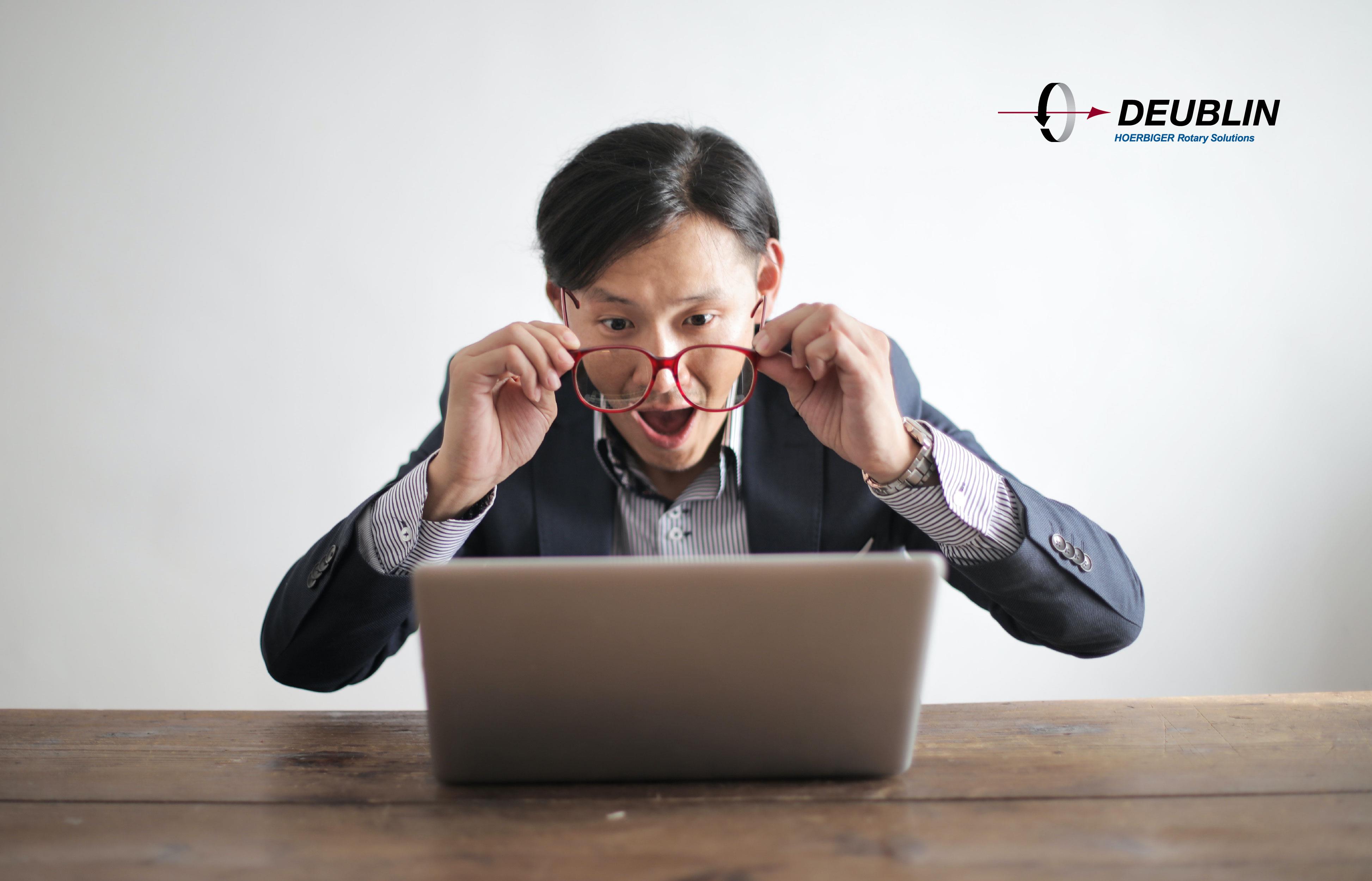 uomo con occhiali davanti a un computer portatile